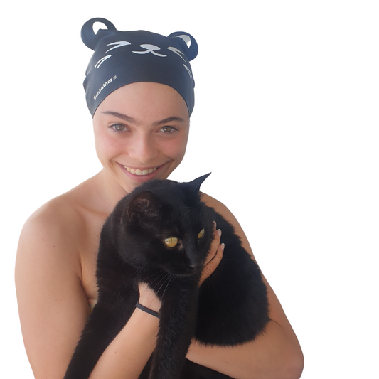Black cat swimcap worn by girl holding black cat named Roxy